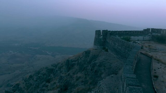 Aerial Profile view of Ranikot Fort (Great wall of Sindh) with foggy landscape at background.