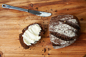 Sourdough, bread and butter on slice for meal, nutrition and carbs on kitchen table or fibre. Top...