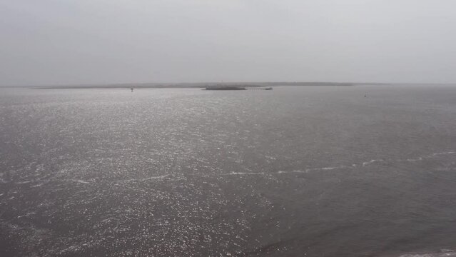 Aerial low rising shot of historic Fort Sumter in Charleston Harbor from Fort Moultrie on Sullivan's Island during a hazy day with low visibility in South Carolina. 4K