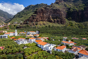 Aerial view of small farming village with banana plantation at Madeira Atlantic Ocean coast - 779405443