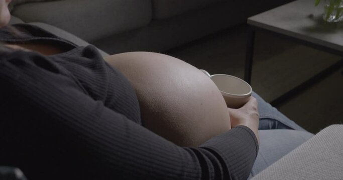 Close up of heavily pregnant woman's baby bump
