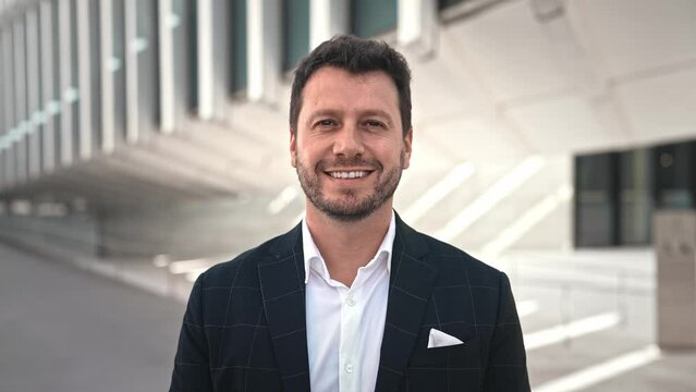 Handsome 30s top manager portrait formal suit. Successful entrepreneur look at camera. Confident business man smile. Young male businessman face. Urban city background. 40s employee work. Office boss.