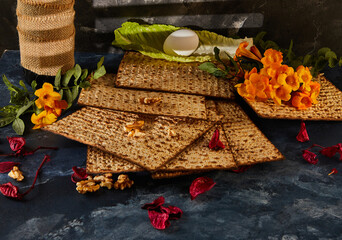 Stack of matzah with flowers and nuts as finger food display on table