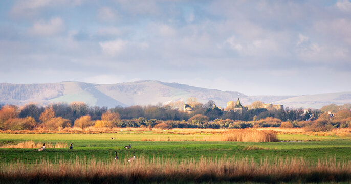 View west of Pevensey and castle with the south downs rising behind in east Sussex south east England UK