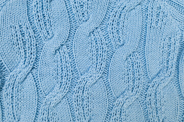 Blue knitted fabric background. Knitted braids texture. 