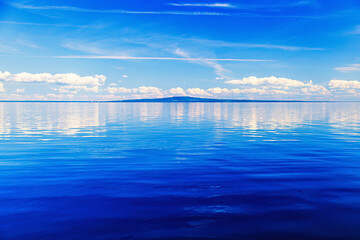 Calm water in Lake Vänern with the hill Kinnekulle in horizon