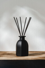 Black Reed Diffuser on a Wooden Table With Soft Light Casting Shadows