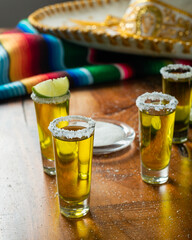 Shots of tequila with salt and lemon on a wooden table. Festive background cinco de mayo and mexican independence day.