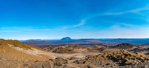 Panoramic view from Askja of Herdubreid volcano in the lifeless volcanic desert in Highlands, with stones and rocks thrown by volcanic eruptions, Iceland, summer, blue sky.