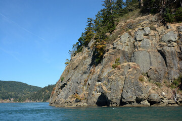 Overgrown cliffs along the waters of the Haro Straight outside of Victoria, British Columbia, Canada on a clear summer day