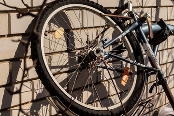 One wheel from an old bicycle against the wall. Close-up image