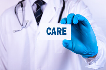 Doctor holding a card with text CARE medical concept.