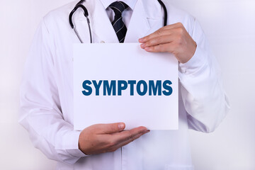 Doctor holding a card with text SYMPTOMS medical concept.