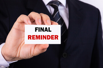 Obraz premium Final Reminder Businessman holding a card with a message text written on it.