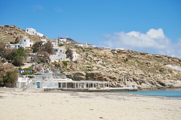Closed beach-front restaurant beneath ocean-front cliffs during the off season in Mykonos, Greece