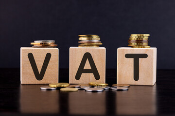 VAT Concept with wooden block with stacked coins