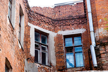 Old destroyed brick building with windows on sky background
