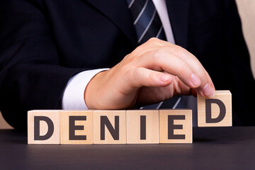 Man made word Denied with wooden blocks. Business concept.