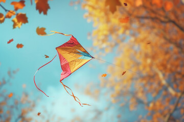 Colorful Kite Flying High Among Autumn Leaves Against a Clear Blue Sky