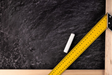Background from a black board with one piece of chalk and a ruler