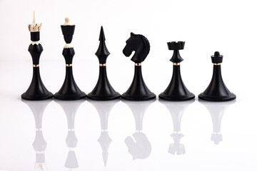 Black chess pieces on a reflective surface. Business concept. Game, strategy, wisdom, determination.