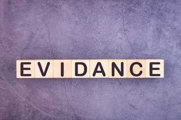 Evidence word written on a wooden blocks on a grey table, concept.