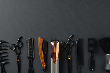 An Assortment of Professional Hairdressing Tools Laid Out on a Dark Surface