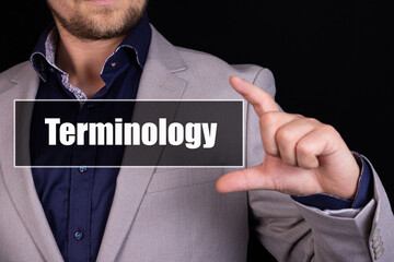Businessman on a black background holds an icon with the text Terminology