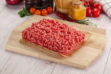 Raw minced beef meat over board