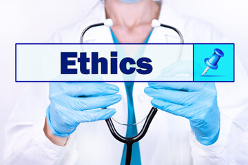 ETHICS text is written on the background of a doctor holding a stethoscope. Medical concept.