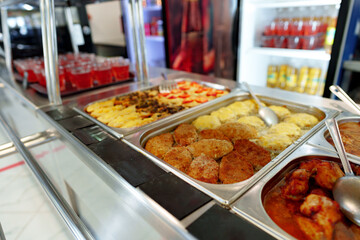 Bustling Cafeteria Serving Line During Lunchtime Offering a Variety of Dishes