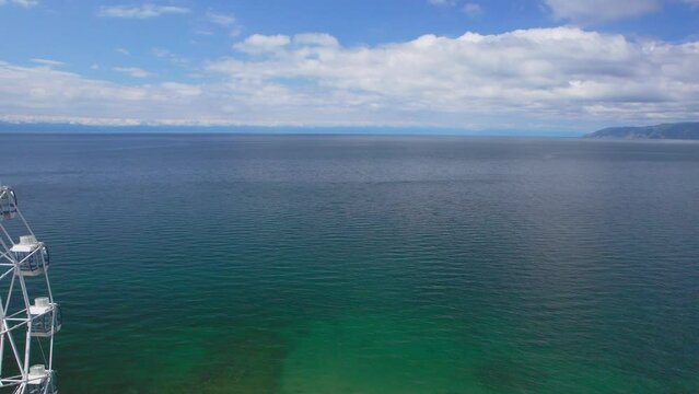 "Capture the breathtaking beauty of Lake Baikal and the Angara River from above in stunning aerial footage. Ships and boats glide through the crystal-clear waters, offering fantastic views.