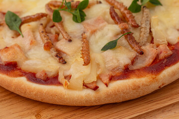 Pizza with bamboo caterpillars and mozzarella, edible insects in Thailand. Close-up