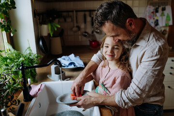 Dad and daughter washing dishes in sink together. Girls dad. Unconditional paternal love, Father's...