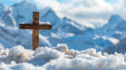 Small wooden Christian cross in middle of snow and snowy mountains in background and copy space