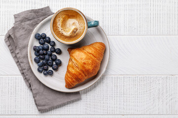 Cappuccino coffee and fresh croissant