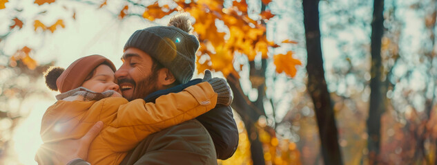A father in a hat hugs his son in a wooded area, surrounded by trees and nature against the...