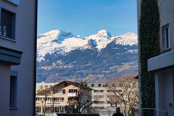 Stunning view of the alps peaking through the buildings of Vaduz, Liechtenstein