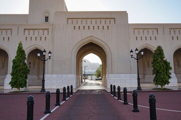 Fototapeta na wymiar Mountain sunset landscape peaking through a traditional Arabian archway at Al Alam Palace in Muscat, Oman
