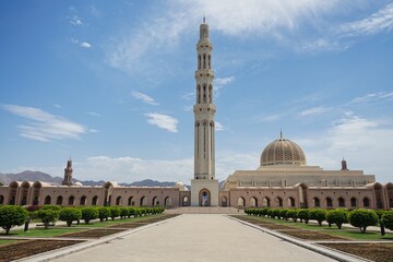 Landscape shot of the vast gardens and complex of the Sultan Qaboos Grand Mosque on a sunny day during Ramadan in Muscat, Oman