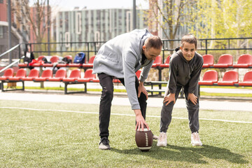 Obraz premium Family Playing American Football Together In Park.