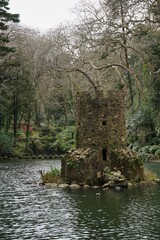 Fototapeta na wymiar Island tower in the center of a picturesque pond on the grounds of the Palace de Pena in Sintra, Portugal
