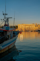 Vista panoramica sul porto di Trani al tramonto con barche e pescherecci di pescatori. Puglia,...