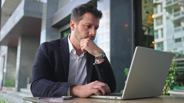 Handsome 30s top manager work laptop. Entrepreneur type computer macbook. Business man look monitor. Young male businessman. Urban city background. 40s employee create start up. Ceo office boss job.