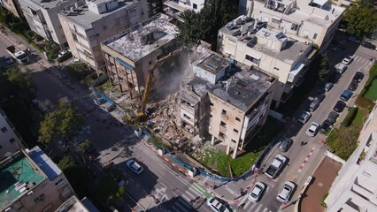 Aerial orbit of building demolition using pincer claw attachment on hydraulic crane