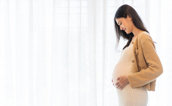 Happy smiling Mother woman hugging and smiling expecting with pregnancy hold baby in belly, woman pregnant, birth, preparation, maternity, care with childbirth at home.Love of family