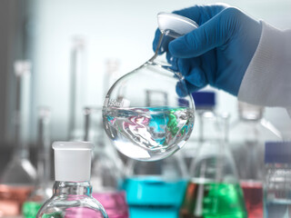 Senior scientist mixing chemical in round bottom flask at laboratory