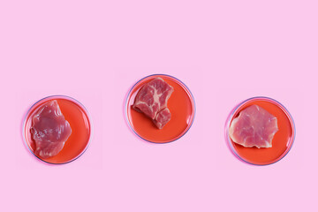 Three Petri dishes with lab-grown artificial meat on pink background