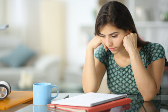 Concentrated student memorizing notes at home