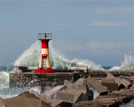 Lighthouse on the pier with crashing waves